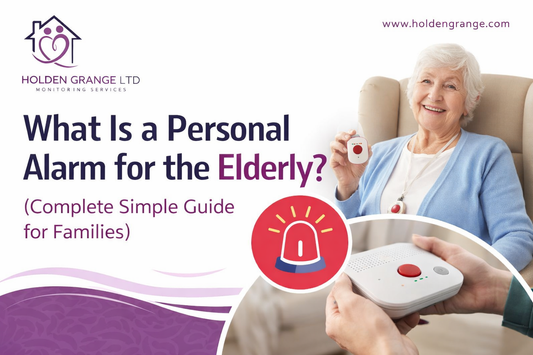 Smiling older woman in an armchair holding a white pendant alarm, with hands holding a telecare base unit